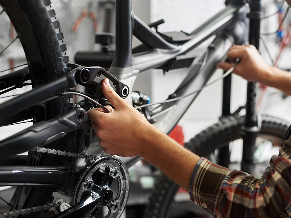 Zuverlässiger Fahrradservice für optimale Leistung – Diermann - Bergsieger GmbH Fahrradmechaniker führt präzise Wartungsarbeiten an einem Mountainbike durch – professioneller Fahrradservice bei Diermann - Bergsieger GmbH